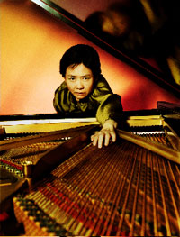 Portrait of Lee Pui Ming stretching over Piano- Photographer: John Launer
